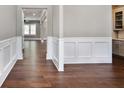 Open hallway featuring hardwood floors, wainscoting, and neutral paint colors to create an inviting atmosphere at 4884 Kentwood Dr, Marietta, GA 30068