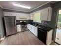 Modern kitchen featuring stainless steel appliances, sleek black countertops, and bright white cabinetry at 2190 Olive Springs Se Rd, Marietta, GA 30060