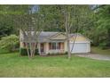 Charming single-Gathering home with yellow siding, red shutters, well-maintained lawn, and attached garage at 2631 Rolling Hills Way, Conyers, GA 30094