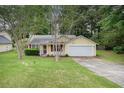 Charming single-Gathering home with yellow siding, red shutters, well-maintained lawn, and attached garage at 2631 Rolling Hills Way, Conyers, GA 30094