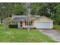 Charming single-Gathering home with yellow siding, red shutters, well-maintained lawn, and attached garage at 2631 Rolling Hills Way, Conyers, GA 30094