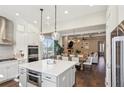 This open-concept kitchen boasts quartz countertops, stainless steel appliances and stylish pendant lighting above island at 3332 Old Concord Se Rd, Smyrna, GA 30082