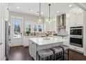 This stunning kitchen features white cabinets, large island with seating, stainless appliances, and hardwood floors at 3332 Old Concord Se Rd, Smyrna, GA 30082