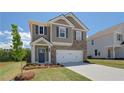 Well-manicured lawn compliments this two-story home featuring shutters, hardiplank and brick, and a two-car garage at 5 Camellia Dr, Fairburn, GA 30213