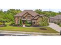 Expansive brick home with manicured lawn, mature trees and a winding driveway at 580 Grimsby Ct, Suwanee, GA 30024