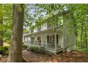 A picturesque view of a home with a classic covered porch, nestled among mature trees and lush greenery at 1519 Brookcliff Cir, Marietta, GA 30062