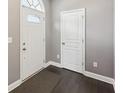 A well-lit foyer features dark hardwood floors, neutral walls, and a white door with glass accents at 3750 Thackary Dr, Powder Springs, GA 30127