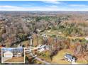 An aerial view of a house and lot with surrounding mature trees on a sunny day at 6045 Mockingbird Rd, Cumming, GA 30028