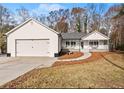 Charming single-story home with a well-manicured lawn, attached garage, and inviting front porch at 6045 Mockingbird Rd, Cumming, GA 30028