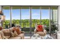 Cozy living room featuring comfortable seating, natural light from expansive windows, and a view of the lush greenery at 700 Park Regency Ne Pl # 1407, Atlanta, GA 30326