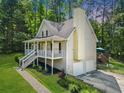 Home's side angle shows a two-car garage, a deck, and a well-maintained yard with mature trees at 411 Hollis Cir, Dallas, GA 30157