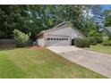 Side view of a well-maintained house, showcasing the two-car garage and green lawn at 525 Forest Pl, Roswell, GA 30076