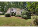 Nicely landscaped home exterior with stone accents and trimmed bushes in a green yard at 525 Forest Pl, Roswell, GA 30076