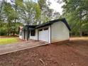 View of the home featuring an attached garage and long driveway at 595 Crowell Rd, Porterdale, GA 30014