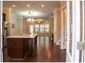 Open kitchen with dark wood island, pendant lighting and hardwood flooring that opens to the living room at 753 Topsail Ln, Alpharetta, GA 30005