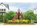 Outdoor view of decorative sculpture on landscaped traffic island with new homes in the background at 753 Topsail Ln, Alpharetta, GA 30005