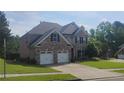 Charming two-story brick home features a two-car garage, long driveway, and manicured lawn at 1481 Park Knoll Trl, Lawrenceville, GA 30043
