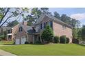 Charming two-story brick home features a two-car garage and a well-manicured lawn at 1481 Park Knoll Trl, Lawrenceville, GA 30043
