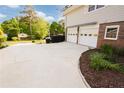 Side view of the home with a two-car garage and ample driveway space at 3407 Larch Pine Dr, Duluth, GA 30096