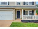 Close-up of a charming front porch with black door, white railing, and manicured landscaping at 408 Sam Cobb Ct, Woodstock, GA 30188