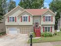 Charming two-story home with attached garages, red shutters, manicured lawn and inviting front entry at 1647 Tunbridge Ln, Lawrenceville, GA 30043