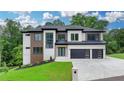 Beautiful two-story home with a modern design, black garage doors, and well-manicured lawn at 165 Westbrook St, Buford, GA 30518