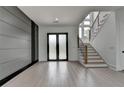 Bright foyer featuring a staircase and double door entry with sleek, modern design at 165 Westbrook St, Buford, GA 30518