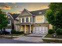 Two-story home with stone accents, blue shutters, a welcoming front porch, and an attached two-car garage at 3380 Labrouste Cv, Duluth, GA 30097