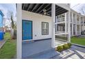 Charming covered porch features a turquoise door, gray concrete flooring, and a ceiling fan at 962 Welch Sw St, Atlanta, GA 30310