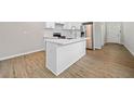 Modern kitchen featuring an island with a white countertop, stainless steel appliances, and light wood flooring at 962 Welch Sw St, Atlanta, GA 30310