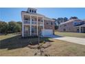 Charming two-story brick home with a double balcony and an attached two-car garage at 228 Chiswick Loop, Stockbridge, GA 30281