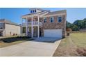 Charming two-story brick home with a double balcony and an attached two-car garage at 228 Chiswick Loop, Stockbridge, GA 30281