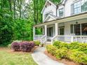 A beautiful home exterior with a large front yard, walkway, and covered front porch with seating at 4910 Conover Dr, Atlanta, GA 30338