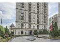 Exterior view of a high-rise building with manicured landscaping and circular driveway at 199 14Th St # 2502, Atlanta, GA 30309