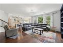 Open concept living room featuring a large sectional, hardwood floors, and natural light at 4630 Carriage Walk Ln, Cumming, GA 30040