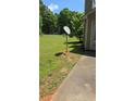 Satellite dish in the backyard with a view of the lawn with trees beyond at 65 King James Se Ct, Conyers, GA 30013