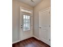 Bright entryway with a stylish front door with glass inserts, a side lite window, and dark wood floors at 1345 Aster Ives Dr, Lawrenceville, GA 30045