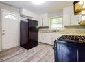 Functional kitchen boasts a black gas range, neutral counters, and white cabinets at 3697 Wisteria Sw Ln, Atlanta, GA 30331