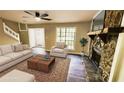Staged living room with a stone fireplace, rug, couch, and chair at 381 Fleming Ct, Jonesboro, GA 30238