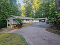 Spacious single-Gathering home with a brick driveway and attached garage in a wooded setting at 5655 Lake Forrest Dr, Atlanta, GA 30342