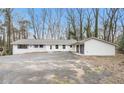 Lovely single-story home with an attached two-car garage and large front yard at 5655 Lake Forrest Dr, Atlanta, GA 30342
