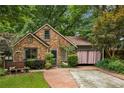 Charming brick home with mature landscaping and a cozy front porch, shaded by beautiful green trees at 725 Brown Pl, Decatur, GA 30030