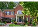 Charming brick home boasts a welcoming front porch and meticulously maintained landscaping at 1676 Grove Park Way, Decatur, GA 30033