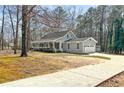 Single-story home with an attached garage, long driveway, and covered front porch at 195 Willow Way, Stockbridge, GA 30281