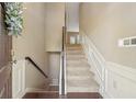 Entryway view featuring a stairway with carpet, wooden floors, and neutral paint at 1257 Park Pass Way, Suwanee, GA 30024