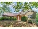 Beautiful single-Gathering home with green siding, stone accents, and meticulously manicured lawn at 255 Nicklaus Cir, Social Circle, GA 30025