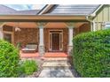 Inviting front porch with stone pillars, seating area, and stylish front door at 255 Nicklaus Cir, Social Circle, GA 30025