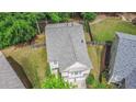 Aerial view of a home with a gray roof, lush green lawn and mature trees surrounded by a wooden fence at 6155 Falls Landing Dr, Cumming, GA 30040