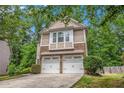 Charming two-story home featuring a two-car garage and a beautifully landscaped front yard at 6155 Falls Landing Dr, Cumming, GA 30040