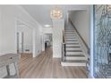 Inviting foyer with hardwood floors, a chandelier, staircase, and view of the kitchen at 1775 Potomac Ct, Lawrenceville, GA 30043